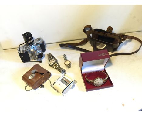 A camera with flash and leather carry case, a light meter with leather carry case and three watches.