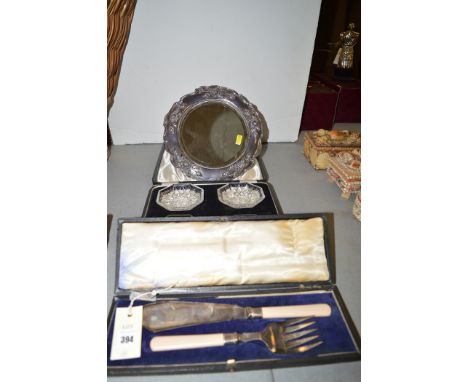 A set of cut glass butter dishes, in fitted case; a plated rose pattern dressing table mirror; and a pair of fish servers, ca