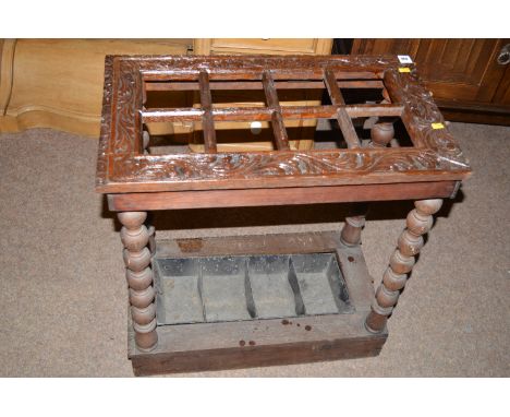 An early 20th Century carved oak stick stand with bobbin turned supports, with original metal liner, 62cms wide.