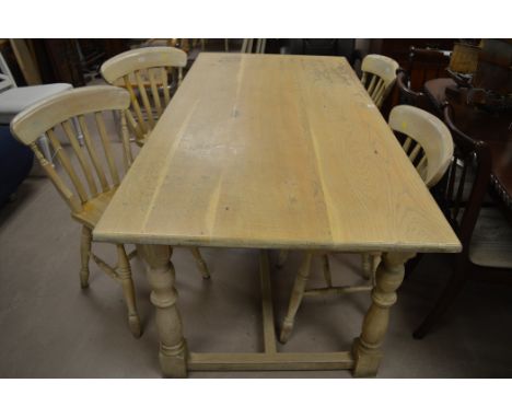 A white painted oak refectory style dining table, raised on turned legs, 183cms long; together with four Windsor style solid 