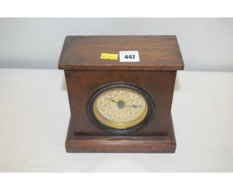 A wooden mantel clock with arabic dial and gilding.