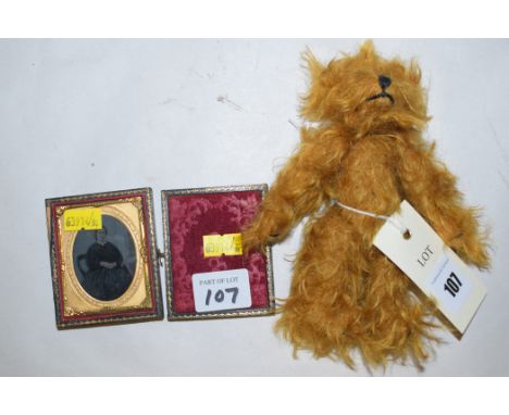 A miniature teddy bear with long gold coloured hair; together with an ambrotype portrait photograph of a lady sitting in a ch