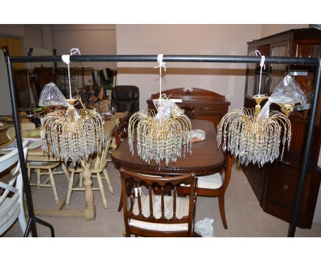 Three moulded glass and gilt metal fountain-style chandeliers, each with three light fittings.