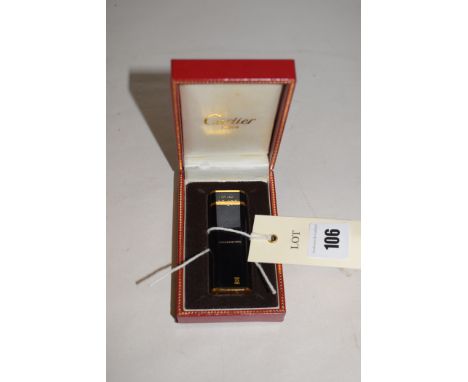 A Cartier gold plated and black enamel lighter, signed and numbered 06965F, boxed.