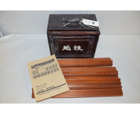 A Chinese Mahjong set with wooden racks and instruction manual.