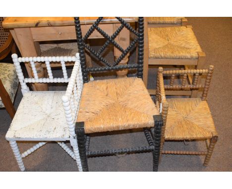 Three bobbin turned chairs: one single chair ebonised; another corner chair painted white; the third in stained. wood.