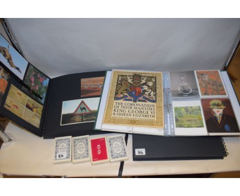 A collection of postcards in three albums; four packs of new playing cards and a Coronation souvenir.