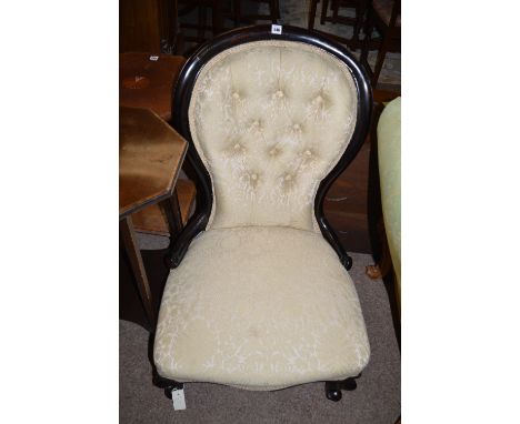 An ebonised balloon back Victorian style nursing chair with button back.