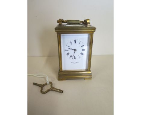 A brass carriage clock, the dial signed Mappin and Webb, with presentation engraving dated 1885. 13cm tall, in good condition