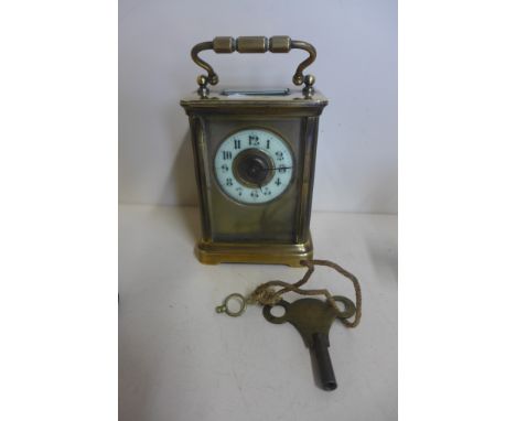 An 8 day brass carriage clock, 12cm tall, with key, running, one glass cracked, chips to front glass 