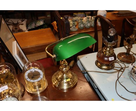 A brass desk lamp with green glass shade