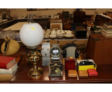 An oil lamp with milk glass shade; and a Lucas cycle lamp with original box; travel clocks etc.