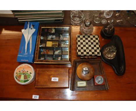 A display case of various ornaments; a boxed model of British Airways Concorde; table lighters; Victorian desk stands; silver