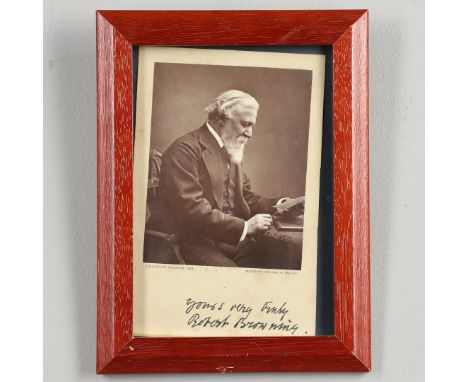 Robert Browning. A postcard photographic portrait, the subject seated at a desk holding a letter, signed in the lower margin 