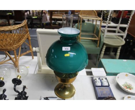 A brass oil lamp with green glass shade