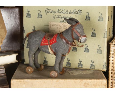 A Steiff grey felt donkey on wheels circa 1908, with black boot button eyes, mohair mane and tip of tail, original red felt s