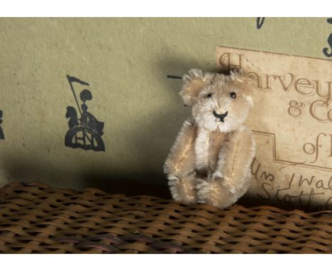 A post-war Schuco miniature Teddy Bear, with beige mohair, black pin eyes, black stitched nose and mouth and metal framed joi