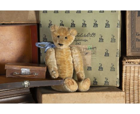 A German Teddy Bear 1915-20, with blonde mohair, black boot button eyes, pronounced muzzle, black stitched nose, mouth and cl