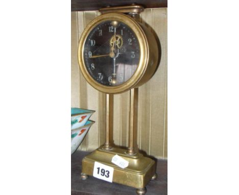 Early 20th c. brass circular mantle clock standing on slender brass supports above a platform base.  The black dial with visi