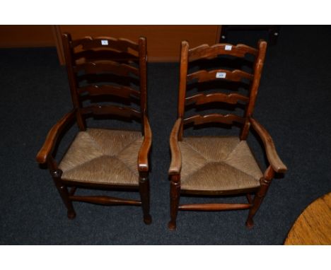 A pair of oak rush seated child's ladder back arm chairs c.1905