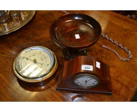 An Edwardian mahogany mantel clock;  a circular wall barometer;  a turned wooden comport (3)