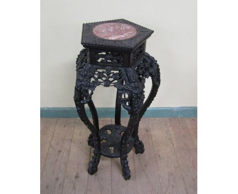 A 19c Oriental marble top pot stand profusely carved with leaf and flowers and supported on four legs with circular under tie