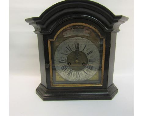 A black painted arched dial mantel clock with an arched brass dial with silvered chapter ring having Roman numerals and arabi