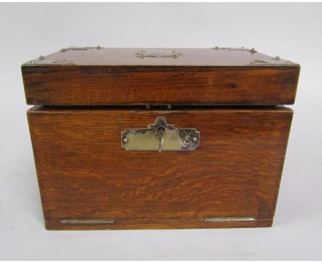 A Victorian oak smokers cabinet fitted with a pipe rack, three compartments with silver plated covers, one having a match str