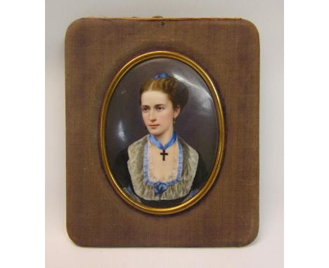 A 19c framed oval portrait miniature of a lady, she wearing a crucifix and blue bow, framed, 9.5cm x 7cm. 