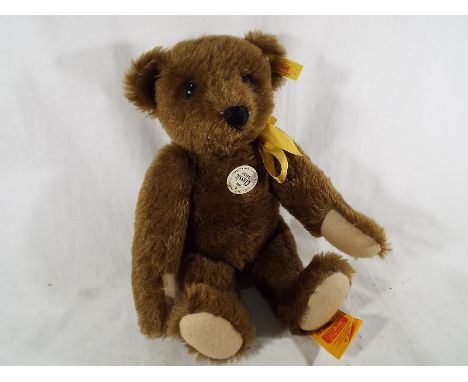 A Steiff mohair bear in the style of a 1909 classic teddy bear, button in ear with tag labels attached 33 cm (h). Estimate £3