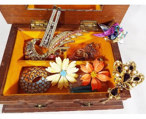 A wooden jewellery box containing a quantity of good quality vintage costume jewellery to include enamelled brooches in the f