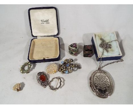 A small collection of vintage costume jewellery consisting of 5 brooches and a white metal locket, include in the lot are two