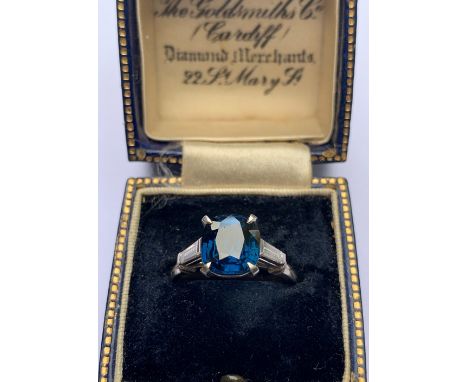 A Burmese sapphire and diamond ring, the central rectangular cushion cut sapphire (measuring approx 3.58ct), within a four cl