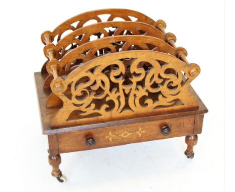 A Victorian figured walnut Canterbury, the four fretwork dividers creating three divisions, above a single frieze drawer, rai