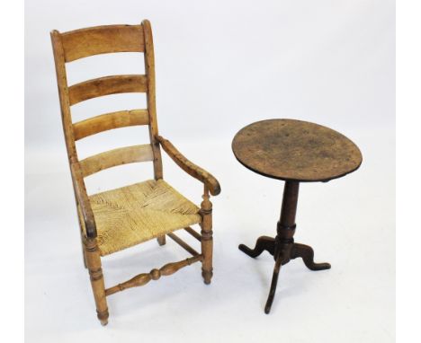 A George III oak tripod table, the circular tilt top on a ring turned tapering column extending to three cabriole down swept 