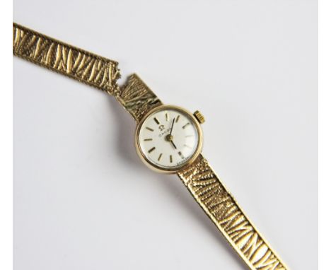 A lady's vintage 9ct gold Omega wristwatch, the cream circular dial with baton markers, set to a plain polished 9ct gold stra