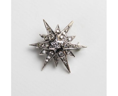 A Victorian style diamond and 18ct gold starburst pendant/brooch, the central round brilliant cut diamond weighing an estimat