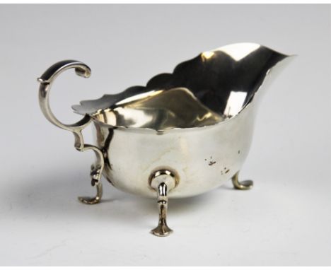 A George V silver sauce boat and ladle by Martin Hall &amp; Co Ltd, Sheffield 1918, the sauce boat with shaped rim and c-scro