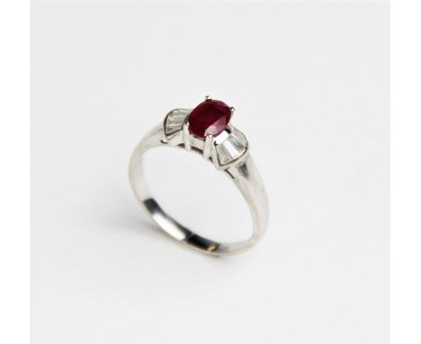 A ruby and diamond 18ct gold ring, comprising a central oval mixed cut ruby measuring approx. 7mm x 5mm, with five tapered ba