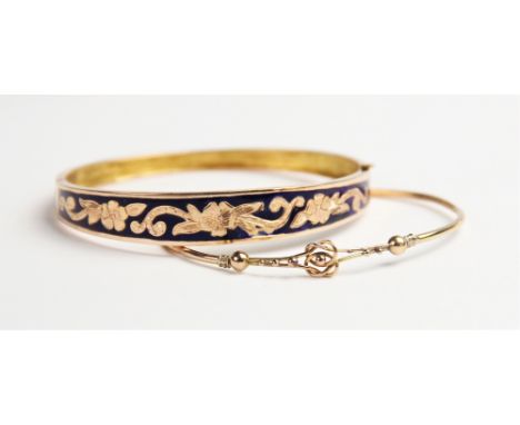 A blue enamelled yellow metal bangle, the oval form tapering bangle with blue enamel and engraved floral decoration to front 