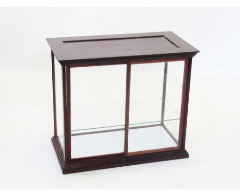 A late 19th/early 20th century mahogany glazed counter top display cabinet, the moulded cornice above a pair of sliding rear 