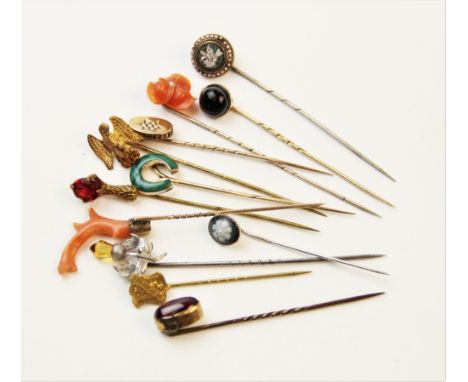 An assortment of Victorian and later stick pins, to include a coral set example, 8cm long, a horseshoe example inlaid with ma