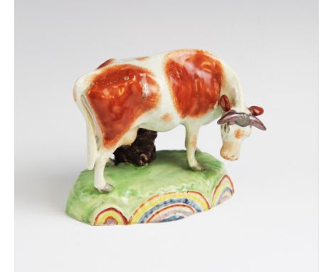 A Staffordshire pearlware cow in the manner of Obadiah Sherratt, early 19th century, modelled standing with head down, set to
