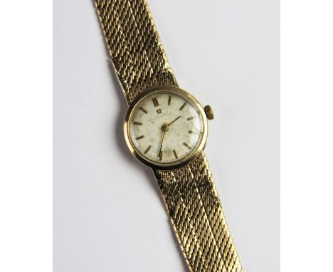 A lady's vintage 9ct gold Omega wristwatch, the circular silver dial with baton markers set to a plain polished 9ct gold case