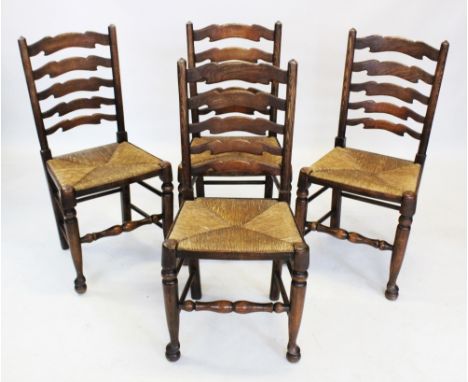 A set of four 18th century style oak ladder back kitchen chairs, 20th century, each with five graduated rungs above an envelo