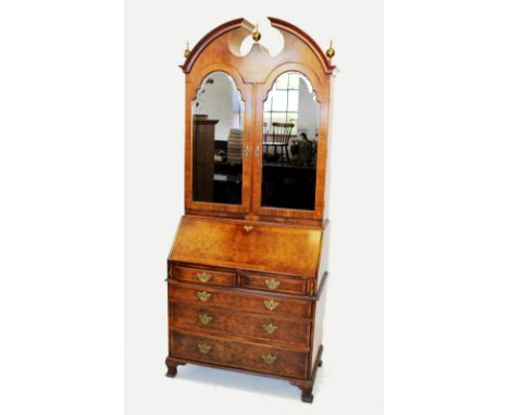 A Queen Anne style walnut bureau bookcase, mid 20th century, with a broken arch moulded pediment punctuated with three brass 