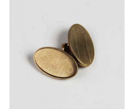 A single 9ct gold cufflink, of oval form with engine turned decoration, 20mm x 13mm, weight 6.8gms 