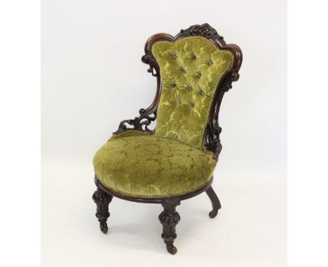 A Victorian walnut and upholstered nursing chair, the shaped button back within a carved 'C' scroll openwork frame, over the 