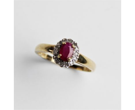 A ruby and diamond 9ct cluster ring, comprising a central oval mixed cut ruby measuring 6mm x 4mm, with a cluster surround fo