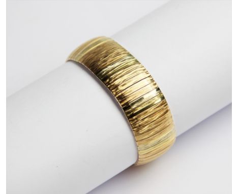 An 18ct gold three colour bracelet, comprising alternating panels of yellow, white and rose gold with engine turned decoratio